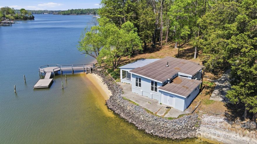 PREMIER WATERFRONT BUILDING OPPORTUNITY on the Mecklenburg side of Lake Wylie! Situated on an approximately 0.74 acre lot with expansive water views and direct access to the main channel, this property offers an exceptional canvas for new construction in a highly sought-after location.  The existing 2-bedroom, 1-bath home is in poor condition and is being sold as-is, making this an ideal tear-down for builders or buyers looking to design and build a custom waterfront residence. The lot’s gentle topography and wide water frontage provide outstanding potential for maximizing views and outdoor living space.  Property includes an older boat ramp in need of repair, offering the opportunity to re-imagine and enhance water access to suit your vision. Surrounded by a mix of renovated and newly constructed homes, this property is perfectly positioned for redevelopment and long-term value.  Rare chance to secure a prime waterfront lot on Lake Wylie.  Bring your builder and create your dream home!