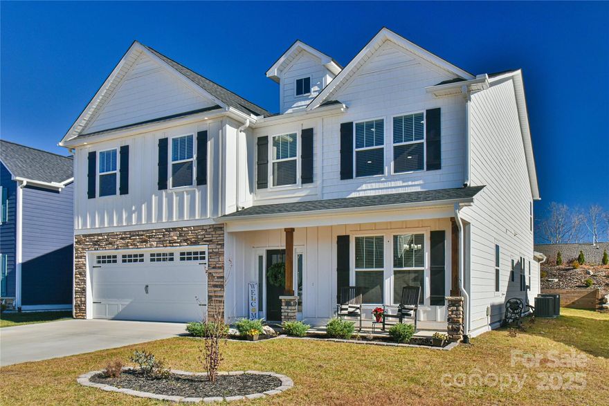 Sellers are offering a $5000 credit with an agreeable offer!  Welcome to this stunning home with the largest floor plan available in the neighborhood. As you drive up you are greeted with a clean exterior with a pop of stone, board and batten elements and a great front porch for relaxing. Once inside, there is an open floor plan with engineered hardwood throughout the lower level. Ample natural light coming in helps accentuate the beautiful shiplap covering the fireplace in the Great Room and the stone wall by the Dining table. The Kitchen and rest of the downstairs are lightly colored to help increase the spacious feel of the already large-sized home. Out back there is a hand-laid patio with a covered sitting area perfect for entertaining guests, relaxing on your own, or grilling out during the BBQ season. The owners also added a leveled garden area perfect for growing your own herbs and vegetables or adding additional greenery to the landscaping. The primary bedroom is on the lower level with plenty of space, a walk-in closet, and a custom barn door to add to the rustic feel. Moving up the stairs there is a lovely grid-style decorative panel as you make your way to the sizable loft, currently used as a theater room with raised seating and surround sound hookups. The remaining upper level boasts three large bedrooms and two full bathrooms, as well as the laundry room. Light fixtures have been upgraded throughout the home and chair railing added to many areas for improved elegance. This home is minutes to Airport Rd as well as Hendersonville Rd for quick access to many shopping and dining areas. The subdivision will not begin building again until the Spring of 2026, so this is the best chance to get a stunning home at a great price for this area. Take a look at the video tour to get a better feel for 52 N Christie Ct and book a showing today!