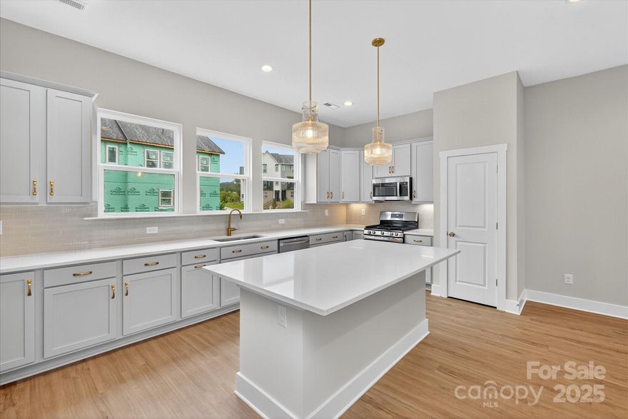 Enjoy the privacy of this first floor guest suite and 2-car garage in this 3-bedroom townhome. The main floor has a private terrace,10 ' ceilings and open living space. The spacious kitchen boasts a large island with quartz counters, tile backsplash, 42" cabinets, LED under-cabinet lighting, and  double trash pull out. Large stainless steel sink, gas oven and range, and dishwasher. The third floor includes primary bedroom with walk-in closet and on-suite full bathroom with tiled shower. The third floor also includes a guest suite including full bathroom.