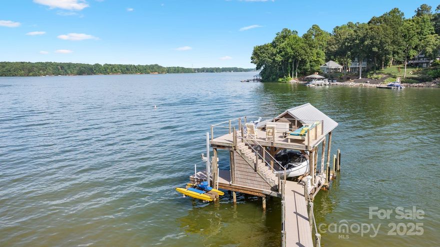 Welcome to your Lake Norman paradise with long range main channel views and the state park. Incredible SUNRISE view with over 150 feet of shoreline. This 3 bed 2/2 bath home with 743 HLA over a 2 car detached garage has been meticulously maintained. Newly renovated kitchen with an open concept and views of the water through the added sliding glass doors. Primary on the main level with screened porch which converts to a 3 seasons room. Walk out basement is finished giving this place incredible opportunities to entertain. 2 bedrooms on second story with adjoining bathrooms & views. Entertain on one of the many decks, patios, screened porch or large flat lot with fire pit on the shoreline. Visit the wine room then head to top level of one of the best docks on the lake with two cable lifts. Refinished hardwoods, windows & workshop add to the ease of living. All of this plus a 743 sq.ft. flex space perfect for a VRBO rental. Privacy yet close enough to grocery, shops and restaurants!