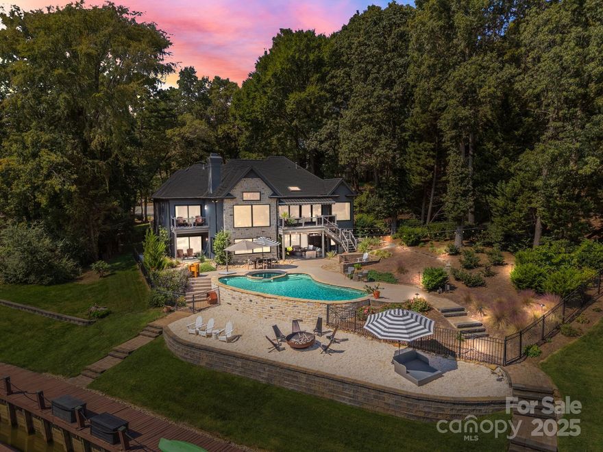 Welcome to 21430 Blakely Shores. This exceptional waterfront residence offers the ultimate in Lake Norman living, with extensive updates that blend modern luxury, timeless design, and everyday comfort. A beautiful arched front door makes a striking first impression, while new premium windows and sliders throughout the home fill each space with natural light and create effortless indoor-outdoor living. The thoughtfully designed layout offers open and inviting living spaces, anchored by a chef’s kitchen featuring a Wolf stove/oven and complemented by a custom-built bar with ice maker, refrigerator, and wine fridge—the perfect hub for entertaining. The spa-like primary suite provides a true retreat with custom closets, heated floors, and a serene atmosphere designed for relaxation. The main level also includes a living room, great room, dining room, breakfast room, laundry, and two additional bedrooms. The finished basement extends the living space with two additional bedrooms, a billiard room, rec room, office, den, and versatile flex space to suit every need. Beyond the walls of the home, a resort-inspired lifestyle awaits: enjoy sun-soaked days by the pool, unwind in the hot tub or sauna, or gather with friends and family around the fire pit. A new custom Trex dock with a 6,000-pound lift makes boating and lake access effortless, while custom landscaping and lighting enhance the grounds and create a vibrant, welcoming outdoor environment. With a sprinkler system keeping the lush grounds healthy and outdoor spaces designed for both relaxation and celebration, every detail enhances the experience of lakeside living. Ideally located near Lake Norman’s best shopping, dining, and recreation, 21430 Blakely Shores is more than a home—it’s a destination for connection, comfort, and exceptional lake living.