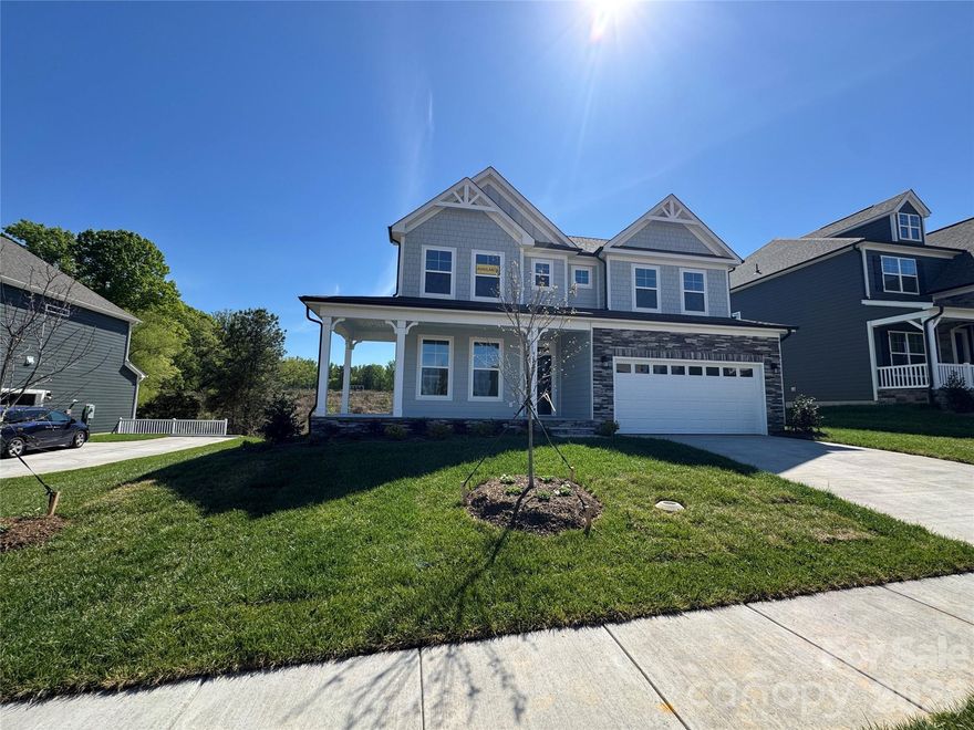 This 2-story Davidson plan with a walk-out BASEMENT has more than 4,000 square feet of living space! The main floor includes a guest suite, a dining room with tray ceiling, and a gas fireplace with shiplap feature wall in the family room. The expanded, designer kitchen has upgraded cabinets & quartz counters, tile backsplash, a stainless range hood, a wall oven & microwave, and a butler pantry that leads to the formal dining room. The upper floor includes a loft, the primary suite with a sitting room, and two secondary bedrooms connected with a Jack-n-Jill bath. The primary bath has a luxury shower with bench seat, two separate vanities, and a linen cabinet. The guest bath on the main has a 4-foot shower with bench seat. The basement features a large rec room along with a bedroom, full bath, and more than 300 square feet of unfinished storage. The rear of the home has a screened-in deck with access through the breakfast area and a patio outside of the basement rec room. Other wonderful additions are a foyer with tray ceiling, a drop zone in the mud room, and quartz counters in all baths. Neighborhood amenities include a pool, dog park, clubhouse & fitness center and future direct access to the paved Catawba Creek Greenway!