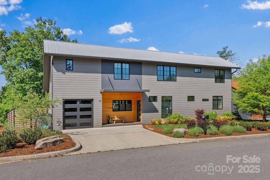 Located in the desirable Malvern Walk community, this modern GreenBuilt home offers the perfect blend of comfort, style and West Asheville charm. With proximity to the Hominy Creek Greenway and Haywood Road’s eclectic restaurants, shops, and gathering places, the location is ideal for those seeking both nature and urban convenience. Inside, three thoughtfully designed levels provide flexible living. The main floor features an inviting open layout with a chef’s kitchen—complete with a gas range and large eat-in island—that flows seamlessly into the dining and living areas. Both spaces open onto a spacious covered back deck, perfect for entertaining or relaxing. The main-level primary suite offers comfort and privacy. Upstairs, a loft-style family room anchors three bright bedrooms, while the fully finished walk-out basement is an entertainer’s dream, complete with a custom wet bar and media area. Throughout the home, hardwood floors, oversized windows, and contemporary lighting enhance the abundant natural light. Outdoors, enjoy a private oasis with raised garden beds, blooming landscaping, a fenced yard, lush lawn, and stone paver fire pit. Be a part of one of the Asheville area’s most sought-after neighborhoods—only 10 minutes from downtown Asheville!