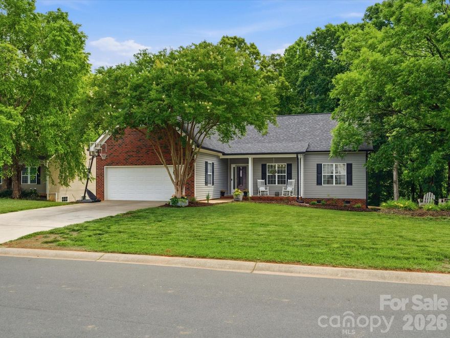 A serene setting, a prime Locust location, and a home that’s been beautifully cared for.  
Welcome to this beautifully maintained home tucked away in the highly desirable Redah Acres community of Locust. This prime location offers convenient access to shopping, restaurants, parks, and Locust Towne Center, while also providing an easy commute to Charlotte, Concord, Albemarle, and Monroe. The setting maintains a peaceful, country feel—truly a hidden gem. A quaint covered front porch greets you with classic charm. Step inside to a welcoming entry foyer that opens into a spacious living area featuring high ceilings and a cozy fireplace. The formal dining room, located just off the foyer, offers generous natural light and a seamless flow into the kitchen. The kitchen is designed for both function and style, showcasing solid-surface countertops, updated appliances, and custom cabinetry that creates a striking focal point. A convenient breakfast bar and adjoining breakfast area provide additional dining options and views into the main living space. This home features a split bedroom layout and an additional bonus flex room upstairs. The oversized primary ensuite is positioned for privacy, and the primary bath includes a soaking tub, double vanity, and a stand-alone tile shower. Situated on a .44-acre lot, the property offers a peaceful, tree-lined backyard that enhances the sense of privacy. The back deck is ideal for outdoor dining, entertaining, or enjoying quiet mornings and relaxing summer evenings. The landscaping complements the serene setting, creating a calm outdoor retreat. A rare opportunity to enjoy comfort, convenience, and a tranquil environment in one of Locust’s most desirable neighborhoods. Redah Acres… where you get convenience, privacy, and that peaceful, country feel. Looking for a home that blends convenience, privacy, and classic charm? This beautifully maintained Redah Acres property in Locust checks every box. New in 2025: Roof, HVAC -trunk line & duct, Gutters, Fenced in Rear Yard, All New Kitchen Appliances. In 2026: Freshly Painted - Foyer, Living, Dining, and Hallway