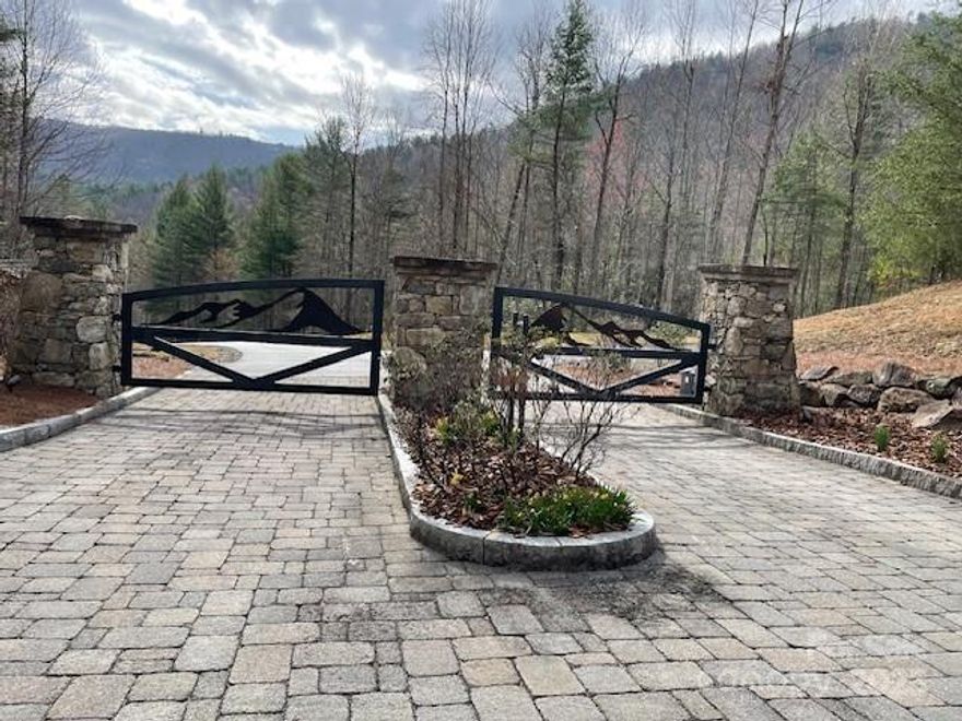 CLOSE TO THE ENTRANCE you will find this gently sloped, level easy build lot in the beautiful, gated community of Round Mountain Falls just 12 miles from downtown Brevard.  Build your mountain home or vacation retreat on this gently sloping lot with several excellent build sites. This property has a small creek adjacent to it as well as community green space with waterfalls, pond and pavilion. And only 3/10 of mile from the entrance, this will satisfy the desire to enjoy a mountain neighborhood, without the steep road to get there.  Approximately 170' road frontage.  See gentle topo lines in photo.  The lot starts at the left near electric box and the neighboring lot pink survey tape.