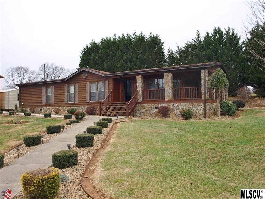 Better than average 3 bedroom, 2 bath Double Wide sitting in a very private setting. Looks like a log home. Extensive professional landscaping, including Stone circle bed with large water fountain, many shrubs and trees. Landscape lighting, recently added stone columns to deck to match the stone underpinning. Enjoy the master bedroom with a walk-in closet, very large bath with new custom built cabinets, jetted tub and large shower. Walk into the front door and see the beautiful rock fireplace that goes to the ceiling which has shelves on both sides. Lots of windows make it bright and cheerful. Kitchen has tons of cabinets and an island. Very private setting, you must see to appreciate all this has to offer.