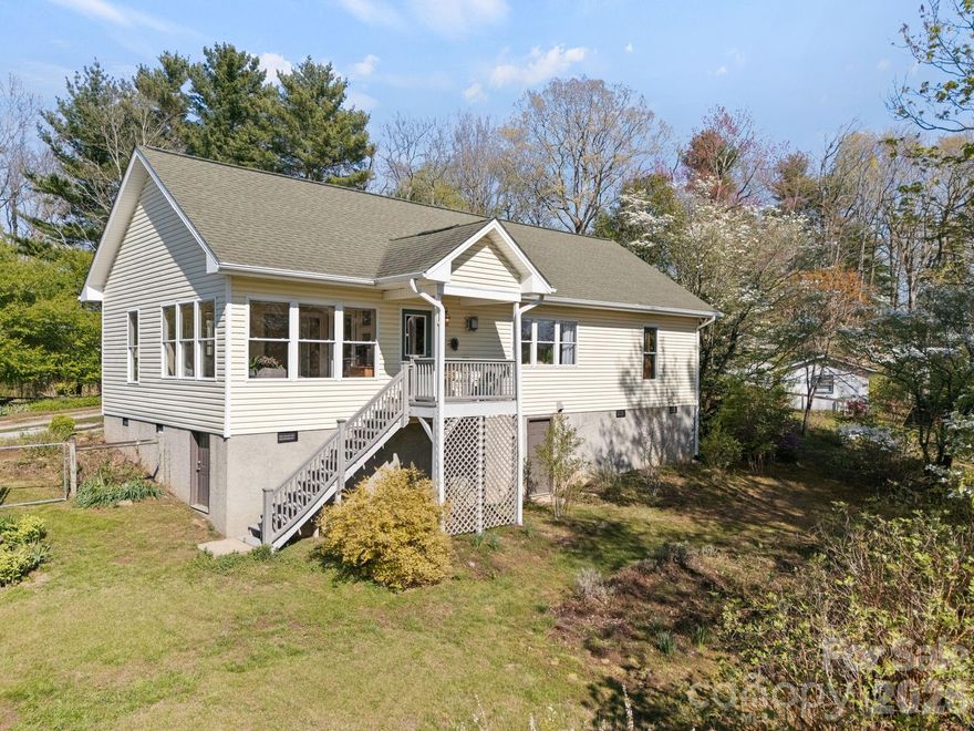 Absolutely charming and truly unique, this delightful home is nestled on .48 acres in a highly desirable location just minutes from downtown Saluda. Surrounded by privacy and a peaceful natural setting, this property offers mountain views and an atmosphere of tranquility that is hard to find. Designed for comfortable one-level living, this two-bedroom, two-bath home features an open floor plan filled with natural light, enhanced by expansive windows that showcase the beautiful landscape. Warm wood floors flow throughout the main living areas creating an inviting and cohesive feel. The spacious living room is anchored by a cozy propane stove and a striking wall of windows, seamlessly connecting to the dining area and kitchen. The kitchen offers beautiful poplar wood cabinetry, tile flooring, and easy access to the deck—perfect for enjoying the serene surroundings. The primary suite provides a relaxing retreat, complete with a well-appointed bath featuring tile flooring, a jetted tub, walk-in shower and generous walk-in closet. A guest bedroom and full bath with walk-in shower offer comfort and privacy for visitors. An inviting sunroom with tile flooring and walls of windows creates the perfect space to unwind and take in the natural beauty year-round. Step outside and experience a truly magical garden setting. The fenced property is thoughtfully landscaped with lush plantings, including blueberries, raspberries, asparagus, and herb garden, along with raised garden beds for the gardening enthusiast. Additional features include a laundry room with washer and dryer included, central vac system as well as convenient access via front steps or a rear ramp. This home is full of character and ideally located just minutes from downtown Saluda, offering the perfect blend of convenience, privacy, and serene mountain living. A rare opportunity to own a peaceful retreat with one of the most enchanting garden settings imaginable.