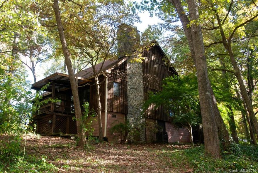 Charming rustic bungalow with dock on Lake Norman. Large fully wooded lot, +/- 1.4 acres. Two porches for lake viewing! Beautiful floor-to-ceiling stone fireplace in great room. The fireplace heater can heat the whole house. Cathedral ceiling. Hardwood floors throughout except MBR is carpeted. Two car detached garage with storage above; there is also a 10x22 storage room or workshop attached to the garage. Circular drive. Fully wooded lot with over 200 trees. Unique property! To be sold "as-is".