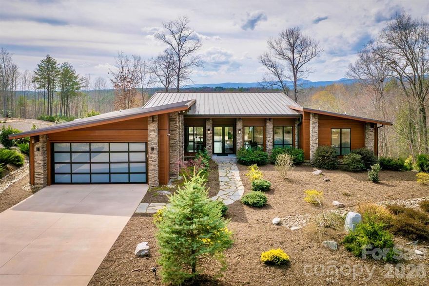 C O M I N G  _   S O O N !    Contemporary, mid-century modern, luxury home with a spectacular view of Table Rock and other Blue Ridge Mountain peaks. This one-of-a-kind custom home is located in The South's premier Outdoor Lifestyle Community, the Coves Mountain River Club.
  • SUPERIOR WALLS® concrete foundation.  Minimal maintenance façade of concrete board and stone columns.  
  • WHOLE HOUSE generator, water filtration and softener system, 500 gallon buried propane gas tank
  • TWO GAS furnaces.   Two on-demand tankless propane water heaters.   
  • 8' FRENCH DOORS IN FRONT.  Contemporary solid wood interior doors.
•       MODERN, SCULPTURAL LIGHTING ARTISTICALLY accentuates the refined, contemporary aesthetic
  • OPEN FLOOR PLAN, resplendent with natural light.
  • A row of motorized windows spans top of wall in living room, providing ventilation and light.  Motorized window shades with magnetic hold-downs to keep in place.
  • TRUE BEAMED vaulted ceilings in living room.  Wood floors.  Sleek linear fireplace.
  • THERMADOR double oven, 5 burner gas stove, under counter microwave
  • CUSTOM WALNUT cabinetry in kitchen and walk-in pantry.
  • COMPOSITE decking on the back porch.  Remote controlled ceiling fans cool the back porch and outdoor kitchen
  • PASS-THROUGH window from the kitchen to the back-porch outdoor kitchen, which has granite counters and built in BBQ with dedicated gas line.
  • LUXURY underfoot in the garage: MetalFX glazed epoxy concrete floor
  • SLEEK stylish, powder room with gleaming black tile wall and modern lighted vanity mirror.
  • HIGHLY FUNCTIONAL, organized, laundry room with built-in cabinetry, ample counter space, utility sink, storage closet.  
  • BUILT-IN bench and cabinets create the ideal drop zone, leaving clutter at the door.
  • LARGE PRIMARY Bedroom Suite with incredible Table Rock view. Luxurious spa bath: large jacuzzi tub, walk-in shower with built-in bench and waterfall shower head. Bidet toilet.  Lighted contemporary mirrors.
  • SPARE ROOM, used as office, has closet; could be 4th BR. 
  • TWO BEDROOMS,  full bathroom, and large great room on basement level.
  • FINISHED walk-out basement opens to a beautiful slate patio and a stone path to 
  • BACKYARD PARADISE  - extensive,  opulent  landscaping with a custom stone raised fire pit transforms the backyard into a luxurious, year-round functional living space
  •.    OUTDOOR GARDENS A  fenced raised garden beds with gate, strawberries, rosemary, blueberry bushes, fig trees, red bud trees, roses, double azaleas, peonies. 
  • XL BASEMENT storage room with interior and exterior entry; double doors for UTV storage and single door exits to back yard gardens.
  • THE COVES MOUNTAIN RIVER CLUB is a 3,200 acre gated community with 5 miles of Johns River on site to kayak, fish, and pan for gold. The crown jewel of The Coves is a post + beam clubhouse, on the highest peak, with 360° views of Grandfather Mountain, Hawks Bill, Table Rock, and Brown Mtn (look for the mysterious Brown Mountain Lights!).  Premium stargazing is ensured by dark sky community protocols (no up lighting etc). Amenities include a saline pool, full kitchen, lending library, fitness center, locker rooms, pool table loft, wrap-around porches and viewing decks to take in spectacular views and sunsets.  Cultivate your private garden plot in the community garden and join your neighbors to harvest grapes in the community vineyard. Hike, bike, or UTV on the community trail system. 2 Equestrian Centers and a thriving Equestrian Club. Join one of the 30+ clubs. Dog Park. Pickle-ball courts, picnic pavilions, river access points. Socials, trips, clubs, yoga. 1.25 hour to Charlotte or Asheville. Minutes to Lenoir, Blowing Rock, Morganton, and the Blue Ridge Parkway.  500,000 acre Pisgah National Forest and Wilson Creek Wild and Scenic River Area are just outside the gates.