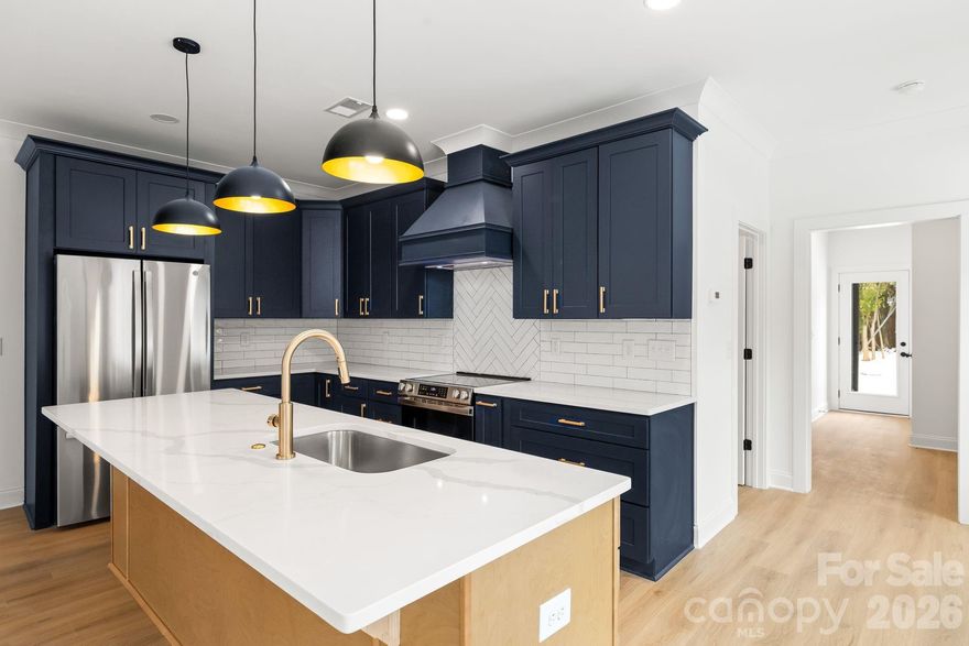 Discover elevated modern living in this END UNIT brand-new townhome - where thoughtful design meets uncompromising style in Charlotte’s most connected pocket. Step through the sleek glass front door into a bright, welcoming entry featuring custom drop-zone built-ins: open shelving, bench seating, and hooks for effortless daily organization. The open concept main level is built for modern, seamless living and effortless entertaining. The chef-inspired kitchen dazzles with quartz countertops, a striking herringbone tile backsplash, custom range hood, premium stainless steel appliances, & an oversized island. Plus a full walk-in pantry with built-in wood shelving. Cozy up by the fireplace with oak mantle in the inviting living area—perfect for gatherings year-round. Upstairs, the oversized primary suite is your private oasis: accent wall, expansive walk-in closet with custom organizers, and a spa-like ensuite boasting dual vanities with gold fixtures, a luxurious floating soaking tub, and an oversized tiled shower with bench. Bonus: direct access from the primary closet to the full-size laundry room for ultimate convenience. Two flexible secondary bedrooms suit guests, a home office, or family needs. No carpet anywhere—clean, modern luxury throughout. Location is everything: Just a short drive to top-rated Oaklawn Language Academy (Spanish immersion magnet), 4 minutes to the vibrant Camp North End (art, food halls, breweries), 2 minutes to Johnson C. Smith University, and quick hops to the Gold Line, Uptown Charlotte, and I-277. Contemporary flair. Premium upgrades. Unrivaled convenience. This isn’t just a home—it’s your next chapter. This home also qualifies for 100% financing with no PMI and up to $10,000 in lender assistance for closing costs, rate buy-down, or loan amount reduction. In addition, the Builder is offering up to $5,000 in closing cost assistance with the use of the preferred lender! Schedule your tour today!