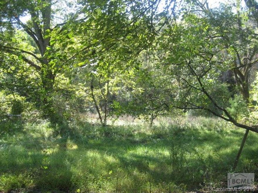 mini farm or private cabin getaway awaits with this 13.6 acre parcel with over 550' of paved road frontage, heavily wooded with older home and several outbuildings. Older home not livable as is. Per owner, timber has not been cut in many years, small creek on property. Must See!