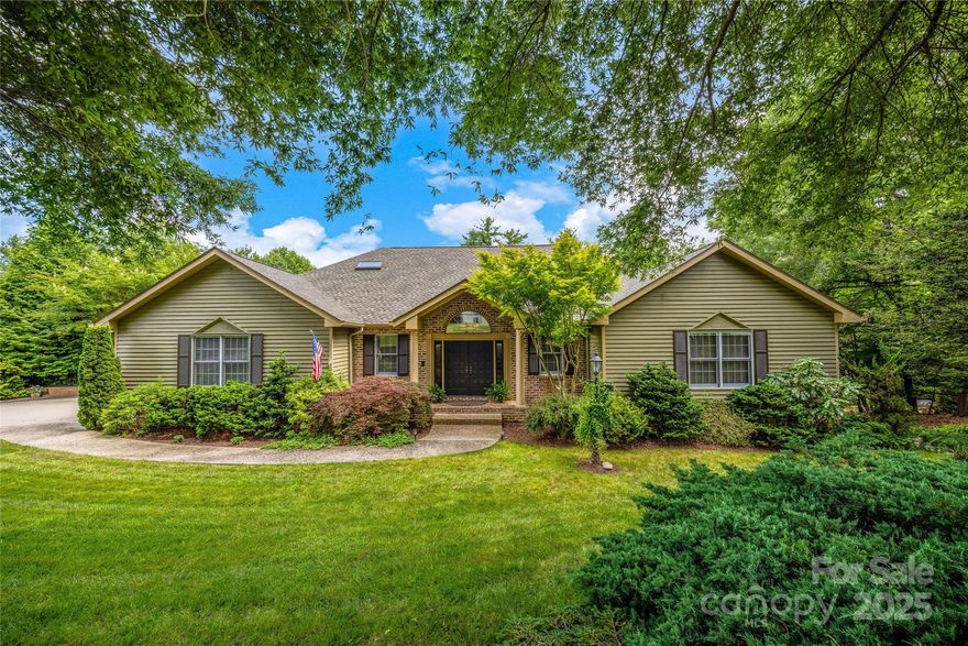 Nestled in the picturesque Wilson Farm subdivision, this stunning 4BR/5BA home offers the perfect blend of natural beauty and convenient location. Surrounded by mature trees and lush landscaping, enjoy peaceful living just minutes from downtown Hendersonville and the Ecusta Trail. The main level features a gracious entryway, rich cherry hardwood floors, a formal dining room, and a dramatic living room with vaulted ceilings, exposed beams, and a beautiful brick fireplace. A sun-drenched four-season room with wraparound windows invites you to relax and enjoy the surroundings. The main level also includes a spacious primary suite with a luxurious bath and walk-in closet. Upstairs are three comfortable bedrooms and two full baths. The lower level offers a private mother-in-law suite, full bath, and a dedicated hobby/sewing room. A rare opportunity to own a home that offers both privacy and proximity—don’t let this one pass you by.