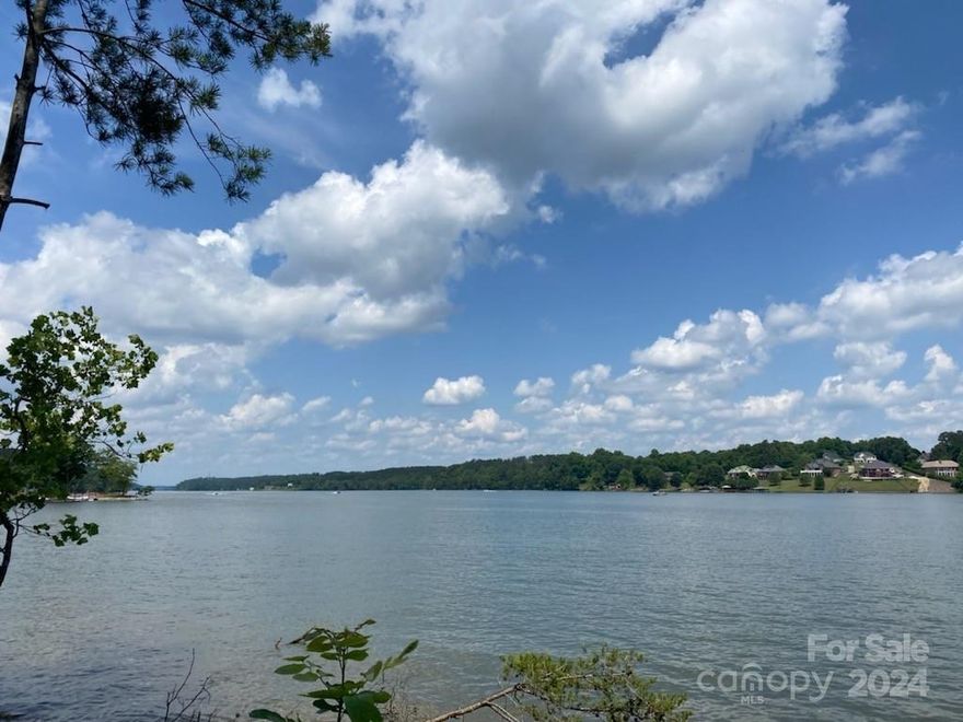 Embrace the serenity of lakeside living with your own private beach on over 200 feet of shoreline. Located directly on Lake Rhodiss, this gated community offers several lake access and common areas including a paddleboard/ kayak storage and launch area, walking trails, pickleball courts, open air clubhouse with in ground salt water pool overlooking the water, and more! Store boats and/or RVs directly on property. This gorgeous property over 100 acres of protected land with private paved roads and underground utilities, already installed and ready for hook up. Building made easy with partial clearing complete, and just enough tree coverage to build your backyard oasis. This lot offers a wide open view of the lake and local mountain view. Deemed dockable and soil testing complete. Looking for an investment opportunity? With a commute of an hour and a half Charlotte, Boone and Asheville, this subdivision is a prime location for short or long term rentals.