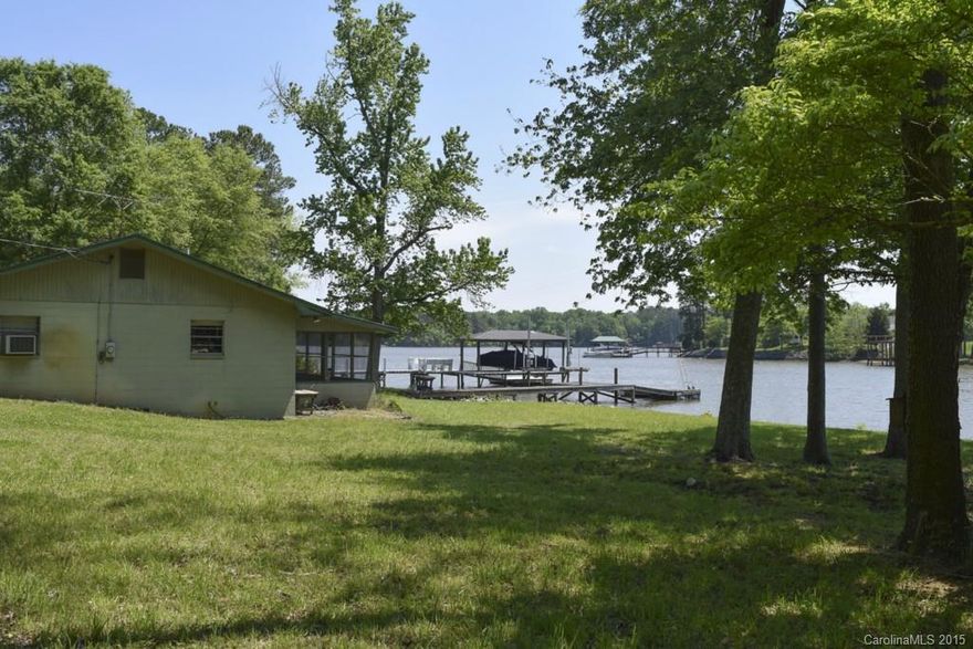 Ready to enjoy the summer on Lake Wylie!  Clean and well tended cabin on the Allison Creek peninsula. Surrounded by nice custom homes, use as a vacation home or build your own custom waterfront. 285' shoreline stabilized, super level w/ beautiful flowering hardwood trees. Dock & boat ramp (grandfathered in) for easy access to the water. Screened porch to enjoy the outdoors. Spacious kitchen is open to the living area, with a fireplace for cool evenings. Open view of Big Allison inlet. See tour!