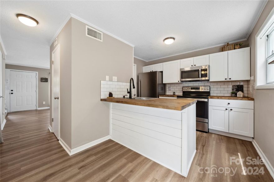 Welcome home to this fabulous 2 bed 2 bath end unit townhome backing up to wooded common space.   Kitchen features a breakfast bar, SS, butcher block countertop, and pantry space. Bright and airy living room.   Sliding glass doors lead to patio with privacy wall and storage closet overlooking wooded common area. Fridge, washer, dryer convey. Community features a pool and clubhouse. Convenient to shopping, dining, just minutes to Hwy 85.  New 16 SEER Heat Pump with Phenomenal Aire Filter in 2022. Hot water heater 2022. Two assigned parking spaces.  Don’t let this one pass you by!