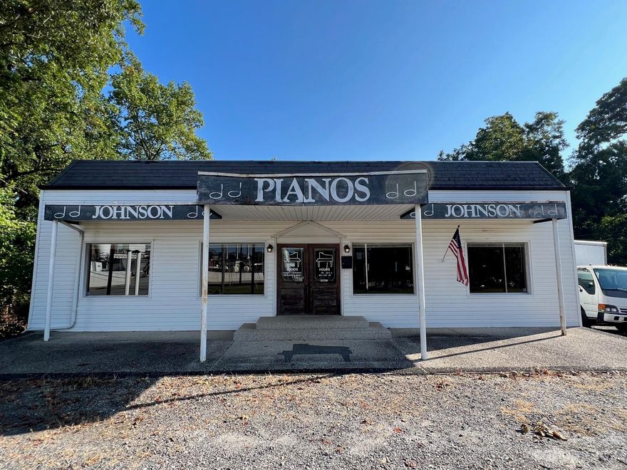 Recently reduced! After being used as a Piano store for many years, this building is ready for a new owner.  Lots of character with hardwood floors and tongue and groove wood paneling on the walls & ceiling.  Large, open retail area with a few private offices, bathroom, and small kitchenette.  Full, unfinished basement for additional storage.  Large lot (.78 acres) that slopes down to a small creek and comes with a free standing storage building.  Great opportunity for a small business!