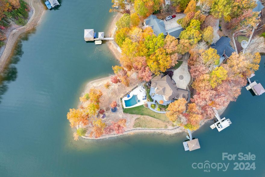 With stunning Lake Norman main channel views from every room and 600+ ft of shoreline, this incredible home is nestled on a peninsula lot w/ over an acre of privacy. Offering style & comfort, this 4bd 3.5ba home is an entertainer’s dream. Exquisite Great Rm: Lots of natural light with a wood-plank cathedral ceiling & wood-burning FP. Kitchen: SS appliances, incl Viking gas stove & hood, 2nd electric stove & warming drawer. With jaw-dropping views, the breakfast nook & wet bar round out the space. Main floor Primary: 2 walk-in closets & spa-like en suite w/ clawfoot tub, walk-in steam shower, & marble throughout. Dining rm, office, laundry & mudroom complete main level. 2nd level has 3bd 2ba w/ bonus rm & walk-in attic storage. Outdoor Paradise! Enjoy a private covered dock w/ boat lift or relax in the salt water pool & spa, w/Travertine decking, outdoor kitchen/bar w/grill-smoker & gas fire pit. Large wraparound deck. Gazebo on point w/addl wood fire pit. A rare find & a must-see!