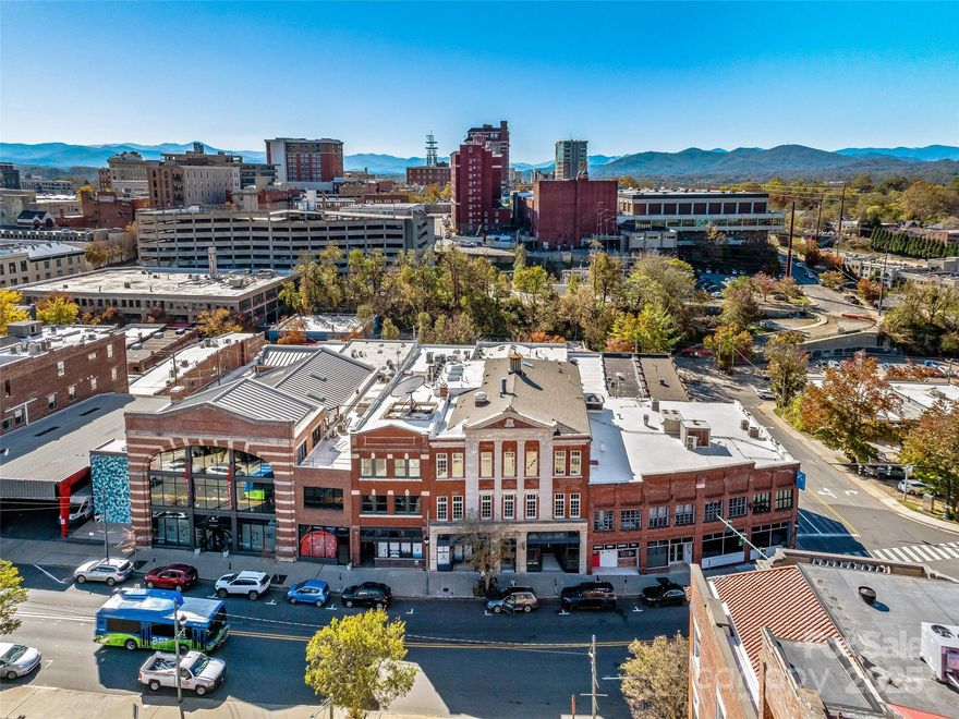Timeless elegance and modern ease define this magnificent downtown Asheville home offering the highest level of luxury with design by George Studio, Inc, (NY) architecture. Custom details include wide plank flooring from France, marble baths by Ann Sacks, Venetian plaster walls, and Holly Hunt lighting. The soaring great room offers exposed beams and brick, highlighted by an expansive library wall. The large stainless kitchen and island compliment the open concept of this home. Enjoy two primary suites with stunning baths and a bright and sunny day room with views of downtown Asheville and the mountains beyond. This HGTV Award winning home includes a climate-controlled garage with four parking spaces and two large storage rooms. There is private direct elevator access to this reconstructed Richard Smith Building, (Architect of the Biltmore)condo with one-level living.  Walk to Harris Teeter, Whole Foods, Trader Joe's. Outstanding luxury, striking from every angle!