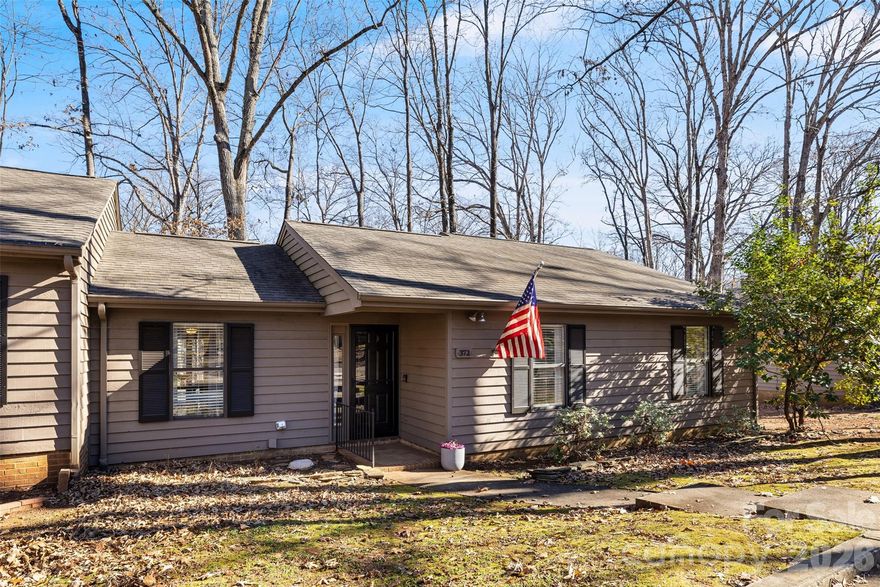 372 Tall Oaks Trail is small but mighty and perfectly positioned for Fort Mill schools and low SC taxes. This 3-bedroom, 2-bath END unit condo proves that smart design and bold style can make a big impact in a compact footprint.  Kitchen has stainless steel appliances and quartz countertops with a breakfast bar and dining area that opens to private deck perfect for morning coffee.  Staged and completely move-in ready, featuring easy-care laminate wood flooring, large closets, and a wood-burning fireplace with stacked stone surround and hearth that anchors the living space.  Convenience matters with a 2-car driveway—a rare bonus for condo living. Maintenance-free ownership means more time to enjoy life and less time worrying about upkeep.  An ideal opportunity for first-time buyers, downsizers, or anyone wanting entry into Fort Mill without the price tag of single-family living.  Roof in 2019, great location close to Anne Springs Close Greenway, Charlotte-Douglas Airport, I77, Riverwalk in Rock Hill, Kingsley for shopping and dining.
