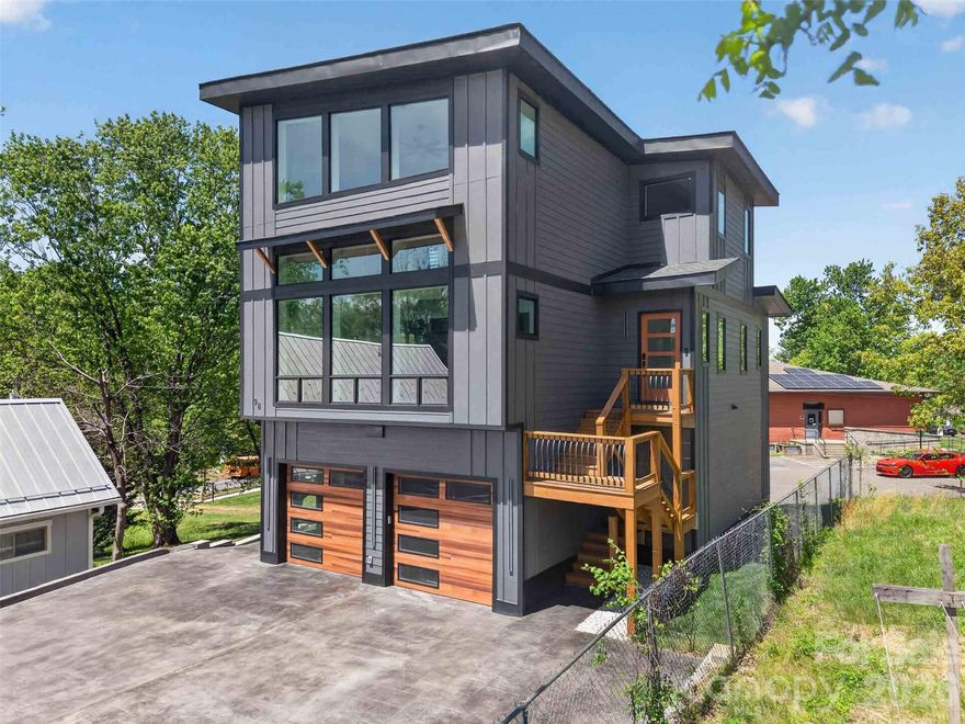 Experience the perfect blend of modern luxury, cutting-edge smart home technology, and exceptional walkability in this newly constructed contemporary residence located in the heart of highly sought-after West Asheville. Positioned just moments from the energy of Haywood Road, this home places you within easy reach of some of Asheville’s most celebrated destinations, including Biscuit Head, Sunny Point Café, Nine Mile, The Admiral, and Plant, along with local favorites like Hole Doughnuts and Odd’s Café. Enjoy nearby breweries such as New Belgium Brewing, Archetype Brewing, and Wedge Brewing, plus quick access to the River Arts District, the French Broad River Greenway, and downtown Asheville just minutes away delivering a lifestyle that is as vibrant as it is convenient.

Thoughtfully designed across three levels, this home offers over 3,400 square feet of refined living space with an emphasis on comfort, efficiency, and elevated everyday living. From the moment you enter, you’re welcomed by an open-concept floor plan filled with natural light, clean architectural lines, and seamless flow between living, dining, and kitchen spaces.

The chef’s kitchen is both striking and highly functional, featuring a large center island with breakfast bar seating, walk-in pantry, wine and beverage refrigerator, and a 5-burner gas range. High-end smart features elevate the experience, including a voice-activated exhaust hood, smart workstation sink, and electronic faucets with precise temperature and flow control, blending innovation with everyday practicality.

Throughout the home, fully integrated smart technology enhances both lifestyle and security. All access doors are equipped with advanced electronic entry systems offering key, code, and fingerprint access. Each room includes Alexa-enabled integration tied into Lutron lighting systems, allowing full control of interior and exterior lighting via app or voice command. The home is also network-ready with built-in connectivity and surround sound capabilities, ideal for both daily living and entertaining.

The home offers four spacious bedrooms and four full bathrooms, each designed with a clean, contemporary aesthetic. All bathrooms feature floor-to-ceiling tile and frameless glass enclosures, creating a spa-like experience throughout. A main-level laundry room adds convenience, while the flexible lower level provides additional living space for guests, recreation, or a private home office.

Efficiency meets performance with dual fuel HVAC systems, zoned climate control, and a tankless water heater, ensuring year-round comfort. The attached two-car garage includes a built-in Tesla charging station, reinforcing the home’s forward-thinking design and energy-conscious appeal.

Combining prime West Asheville walkability, proximity to Haywood Road’s dining and brewery scene, and easy access to the River Arts District and downtown, this home represents a rare opportunity to own a truly next-generation property in one of Asheville’s most dynamic and desirable neighborhoods.
