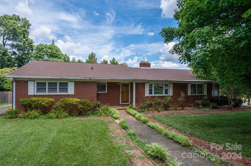 Sought after traditional brick ranch home convenient to shopping and hospital. Gorgeous hardwoods greet you upon entry and carry you throughout most of the home. This beauty boasts an updated kitchen, remodeled hall bath, two fireplaces, and built-ins in the den. The larger bedroom has two closets and the primary suite has a full bath. The sunroom has a step-down for entry and also houses the laundry. A circular driveway makes coming and going much more fluid and the driveway has ample parking including a one-car attached carport to protect from the elements.  The garage is an absolute delight for a car or woodworker enthusiast! Boasting an extra shop area, the building totaling 936 sq. ft. has electricity, water, and gas heat. An inground gas grill and gas dryer will remain. Some of the wood may be left by the owners. Potential road widening project on Cox Rd. may affect property...buyer should educate themselves prior to offer..https://www.ncdot.gov/search/Pages/results.aspx?k=U-6044