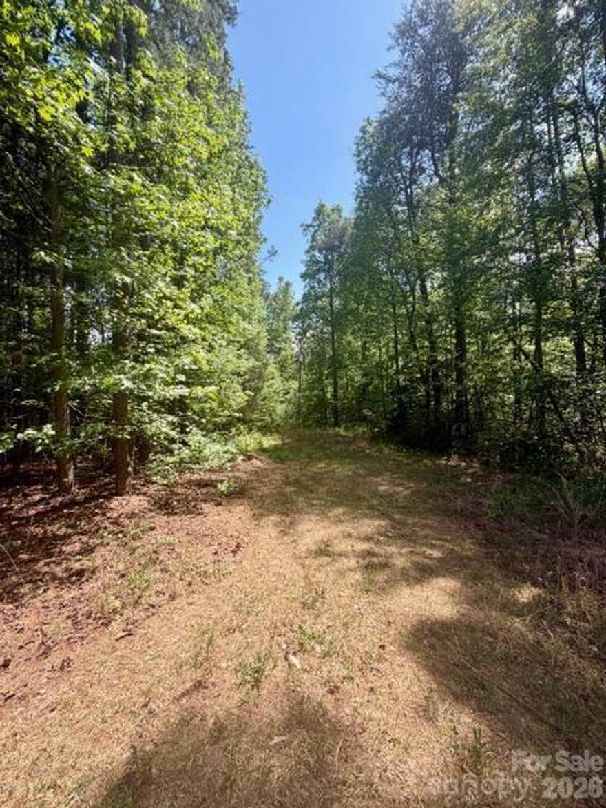 Nestled along Faith Road, this beautiful one-acre parcel offers a serene, wooded setting that’s perfect for building your dream home. The property has been partially cleared, with an abandoned electric pole currently on site that can be removed by the buyer, giving you a head start on preparing the land for construction. One of the few remaining flat lots in Mooresville without the true restrictions of an HOA, this property provides both flexibility and privacy. The only building requirements are a minimum of 1,200 square feet, with no single-wide or double-wide homes permitted, ensuring a neighborhood feel while still allowing you to design a home that suits your vision. While there is currently no well or septic permit in place, this gives the future owner the opportunity to plan and install systems tailored to their specific needs. Ideally located near I-77, the property offers convenient access to shopping, dining, and all that Mooresville has to offer, along with access to highly regarded school districts. Whether you’re envisioning a peaceful retreat or a custom-built residence, this spacious, gently wooded lot presents a rare opportunity in a desirable and growing area.