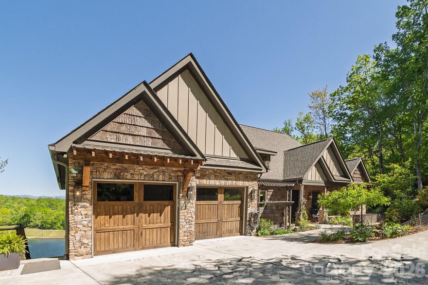 Set along the pristine shoreline of Ticoa Lake in the highly sought-after Connestee Falls Subdivision, this exceptional Arts and Crafts–inspired residence offers a rare blend of refined craftsmanship, thoughtful design, and an unmatched mountain-lake lifestyle. Built by Crone Builders and positioned on a rare double lakefront lot, the property features extensive shoreline ideal for fishing, swimming, paddling, or peaceful lakeside relaxation. Deep-water access, a private entertaining dock, and an included pontoon boat create a truly turnkey lakefront experience.

Please be sure and View this 3D Virtual Walkthrough Virtual Tour. https://my.matterport.com/show/?m=1WLKQEQho8D

Arrival is highlighted by a concrete driveway framed by native stone retaining walls and custom wood railings, seamlessly blending into the natural surroundings. The exterior showcases rich architectural detail with native stonework, bark wood accents, and custom timber elements. A spacious double garage with custom wood doors provides ample storage and includes a Tesla charger.

Inside, the home impresses with soaring tongue-and-groove ceilings, exposed wood beams, rich hardwood floors, and solid wood doors throughout. The great room is anchored by a dramatic floor-to-ceiling native stone fireplace and expansive windows capturing tranquil lake and mountain views, flowing seamlessly to outdoor living spaces.

The chef’s kitchen is both elegant and functional, featuring an oversized Taj Mahal quartzite island, custom wood cabinetry, Wolf and Liebherr appliances, refined pendant lighting, and a custom pantry with coffee station. Open sightlines connect the kitchen, dining area, and great room—ideal for entertaining. The dining area is warm and inviting with wood-encased walls, exposed beams, and year-round views.

The main-level primary suite is a private retreat with deck access, a tray ceiling with wood detailing, a native stone gas fireplace, motorized blinds, and eight-foot solid wood doors. The spa-inspired bath features Philadelphia travertine tile, custom cabinetry with under-cabinet lighting, a spacious walk-in shower, and luxurious heated floors.

The lower level expands the living space with a generous family room centered around another floor-to-ceiling stone fireplace, custom built-ins, and access to a covered lower deck. A well-appointed wet bar with stone countertops, beverage refrigerator, and ice maker enhances entertaining. This level also includes a bonus room, a flex room ideal for office, hobby, or guest use, a dedicated fitness and wellness area with sauna and tanning bed, and over 500 square feet of workshop and storage space, providing exceptional versatility and ample room for projects and lake gear.

Outdoor living is exceptional, featuring approximately 1,145 square feet of covered, open, and screened decks, a private hot tub overlooking the lake, and a gently terraced stone path leading to the dock. Whether hosting gatherings, enjoying quiet mornings, swimming from the shore, or cruising the lake, the expansive shoreline creates a true year-round retreat.

Located within the gated community of Connestee Falls, residents enjoy access to a championship golf course, the Overlook Clubhouse with 26,000 square feet of recreational facilities, a 12,000 square foot Activity & Wellness Center with a full-time program coordinator, miles of hiking trails, tennis, pickleball, and bocce ball courts, a swimming pool with lap lanes, community organic gardens, and multiple community parks including a dog park—all just minutes from downtown Brevard.