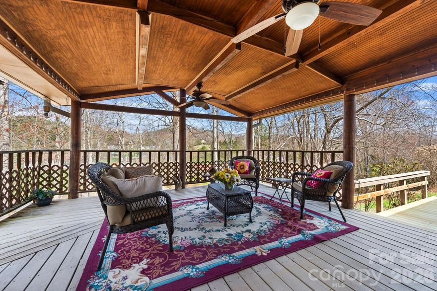 Charming country setting with one level living sitting up on the lot with great privacy.  Spacious home with two large living areas and open concept layout.  Split bedroom plan with Primary BR on one side and secondary bedrooms on other.  Huge kitchen offers abundant countertop space leading into den with gas log fireplace.  Completely updated guest bath with walk in shower.  Enjoy the large covered porch on summer days or the deck on the rear that spans the length of the entire house.  More than 1,800 s.f. of living space, all on one level!  New roof (December 2025) by Balkan Roofing.  Large recently completed detached double carport tall enough for parking an RV.  Down below the house near the street is a parking pad for a 5th wheel or additional guest parking if desired.  The community is a quiet neighborhood with excellent proximity to Asheville.  Generator and detached storage building conveys.  POA dues INCLUDE water from community system.