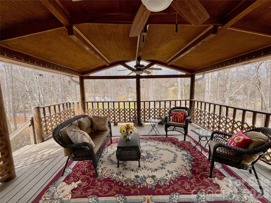 Charming country setting with one level living sitting up on the lot with great privacy.  Spacious home with two large living areas and open concept layout.  Split bedroom plan with Primary BR on one side and secondary bedrooms on other.  Huge kitchen offers abundant countertop space leading into den with gas log fireplace.  Completely updated guest bath with walk in shower.  Enjoy the large covered porch on summer days or the deck on the rear that spans the length of the entire house.  More than 1,800 s.f. of living space, all on one level!  New roof (December 2025) by Balkan Roofing.  Large recently completed detached double carport tall enough for parking an RV.  Down below the house near the street is a parking pad for a 5th wheel or additional guest parking if desired.  The community is a quiet neighborhood with excellent proximity to Asheville.  Generator and detached storage building conveys.  POA dues INCLUDE water from community system.