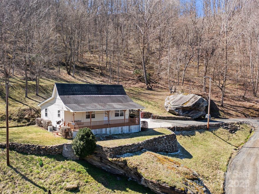 This charming cottage has been completely restored, preserving its original beauty while adding modern comforts. Renovations include new wiring, insulation, plumbing, drywall, and stunning tongue-and-groove hickory floors. The home features two spacious bedrooms with large closets, a generous bathroom, and a mudroom with laundry hookup and exterior access. The open galley kitchen, living, and dining areas feel bright and airy. A gas furnace and central air ensure year-round comfort. Perched above the Toe River, the property boasts breathtaking views, historic stacked stone walls, and a unique rock formation. Ideal as a weekend getaway or Airbnb rental! Home and property did not suffer any damage during Hurricane Helene. Property sits well above Helene flood level and is not in a flood zone.