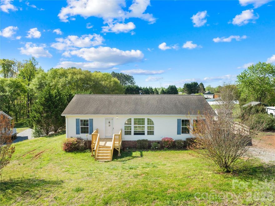 Situated on 1.19 acres this 3 bedroom, 2 bathroom home offers space, privacy, and convenience. The open-concept layout creates an inviting flow between the living room, dining area, and kitchen, making the home ideal for everyday living or entertaining. The spacious living room features LVP flooring, abundant natural light, and a center fireplace that adds warmth and character. The kitchen offers ample cabinet space, a functional layout, and a breakfast bar. The split-bedroom floor plan provides added privacy, with the primary suite tucked away featuring an en-suite bath complete with soaking tub and separate shower. Step outside to enjoy the large backyard and rear deck, perfect for relaxing, entertaining, or enjoying the surrounding greenery. With over an acre of land, there is plenty of room for outdoor activities, gardening, or future improvements. Located approximately 10 minutes to Downtown Shelby, this home offers easy access to shopping, dining, and commuting routes while still enjoying a quieter atmosphere.