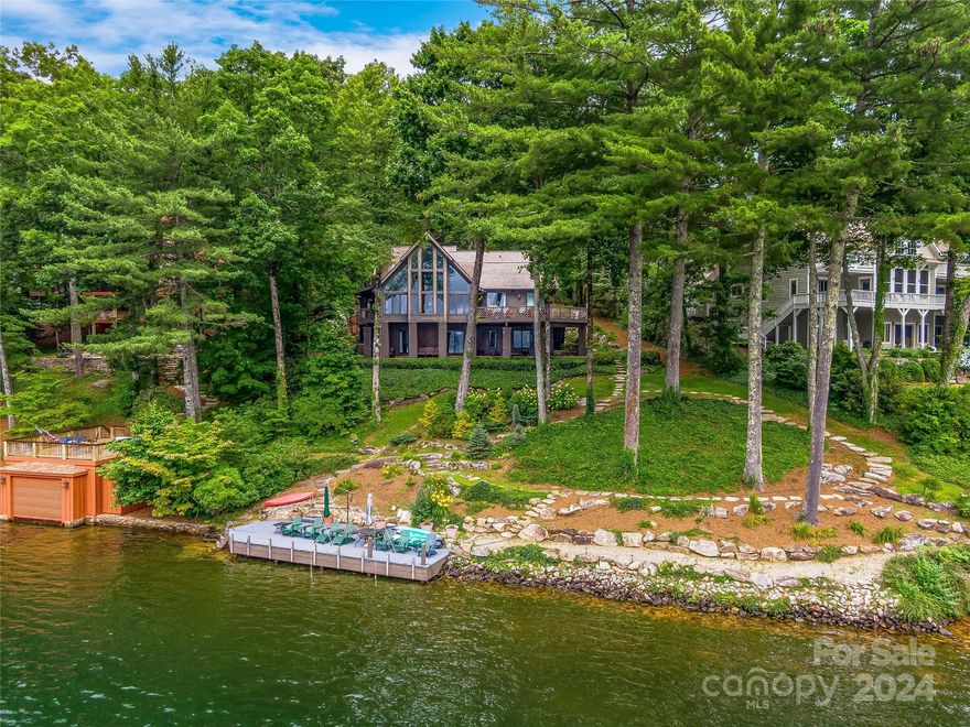 This stunning lakefront retreat features a generous 159’ of lake frontage, two docks, and beautifully landscaped grounds. Step inside the home to be greeted by large picture windows in the main living space, showcasing views of the lake and allowing natural light to fill the home. Step through the kitchen to the dining nook and den area to access the covered porch with skylights and a ceiling fan for warm summer days. The primary bedroom features an updated spacious bathroom and accesses the open air deck. The upstairs space houses an additional bedroom, full bath, and his & her office spaces. The lower level features the third bedroom, full bath and another living space with access to the stone-laid outdoor space where you can descend the native rock path to the water’s edge. Select furnishings convey with property. Located on a private road with minimal traffic and within close proximity to the club, enjoy privacy and easy access to nearby amenities.