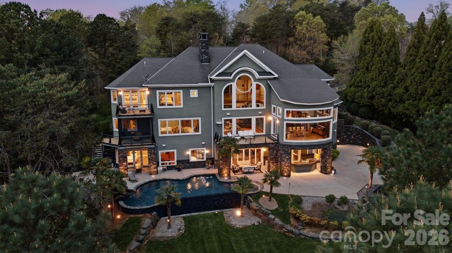 EVERYTHING you can imagine can be yours with this custom luxury lakefront dream estate to include gorgeous long range lake views. No expense was spared! It's an entertainer's dream & engineering marvel w/ incredible spans accomplished by incorporating 80+ steel beams through all levels. The meticulous design optimizes the lake and mountain atmosphere with views of Badin Lake and the Uwharrie National Forest that will touch your heart. You'll feel suspended in tranquility on the upper level as you walk over the glass suspension bridge and walk down the floating spiral staircase.  Your walkout basement with retractable doors includes a 3 tier stadium theater, pool table, foosball table, fully conditioned wine cellar, fully conditioned cigar lounge & humidor, enormous custom bar, infinity zero entry pool with waterfalls and in-pool seating, elevator to all levels, electronic dumbwaiter, OUTDOOR KITCHEN & MORE! Private dock/Covered slip/Boat lift! 5th bedroom currently used as office! Preapproved buyers welcome!