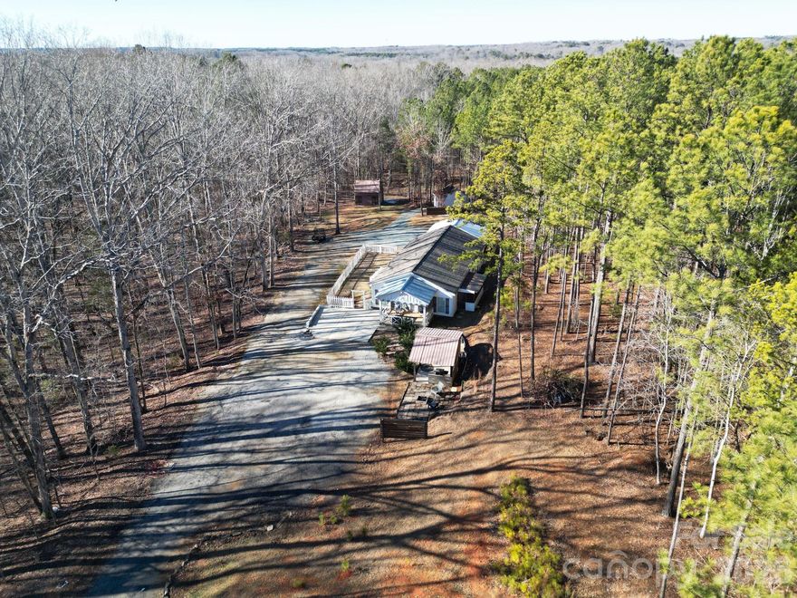Enjoy privacy, space, and flexibility with this 2-bedroom, 2-bath home situated on 2.15 acres in a prime location with no HOA, featuring a desirable split-bedroom floor plan.

As you enter the home, you are welcomed by a generously sized bedroom, followed by an additional flex room—perfect for a home office, craft room, playroom, or bonus space to fit your needs. A full bathroom is conveniently located nearby and leads seamlessly into the heart of the home: a large open living area, a spacious living room with cathedral ceiling, and a dining area that flows effortlessly into the kitchen—ideal for everyday living and entertaining.

Just off the kitchen, you’ll find a laundry room that connects to a large walk-in closet, offering excellent storage and the option to use it as a pantry or additional primary closet. Off the living room and closet is the primary bedroom, complete with an ensuite bathroom featuring a walk-in shower, tub, and a generous walk-in closet.

Step outside from the kitchen onto a screened-in porch, perfectly nestled along the side of the home for relaxing and enjoying the peaceful surroundings. The property also includes a large detached outbuilding with power and its own subpanel, plus a second-level storage area. Two additional outbuildings/sheds provide endless possibilities—workshop, storage, home office, or future guest or granny pod conversion.

Conveniently located near US-521 / Hwy 9, shopping, dining, University of South Carolina Lancaster, and MUSC Health Lancaster Medical Center, this property offers the perfect blend of space, flexibility, and accessibility.