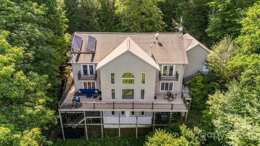 Welcome to your mountaintop masterpiece—where the views stretch farther than your daydreams. Perched high above it all, this home offers jaw-dropping, long-range views from all three levels. Inside, soaring vaulted ceilings and a grand stone fireplace set the scene for cozy luxury. The newly remodeled primary bathroom is ready for candlelit soaking sessions, and the kitchen has two pantries! Need room to work? There are multiple, flexible office spaces. Feeling adventurous? Camp, hike, or just wander your private 3.20-acre backyard forest. Watch the sunset and let the mountain quietly soothe your soul. All this serenity—just 4 minutes to groceries, dining, and daily errands, 5 minutes to the Blue Ridge Parkway and only 15 minutes to the heart of Downtown Asheville. Don’t miss the 360° virtual tour and feature video walkthrough. No HOA. Previous to the current owner, the house was a short-term rental, outside city limits. 11.88 kWp solar and backup battery. EV charger in garage.