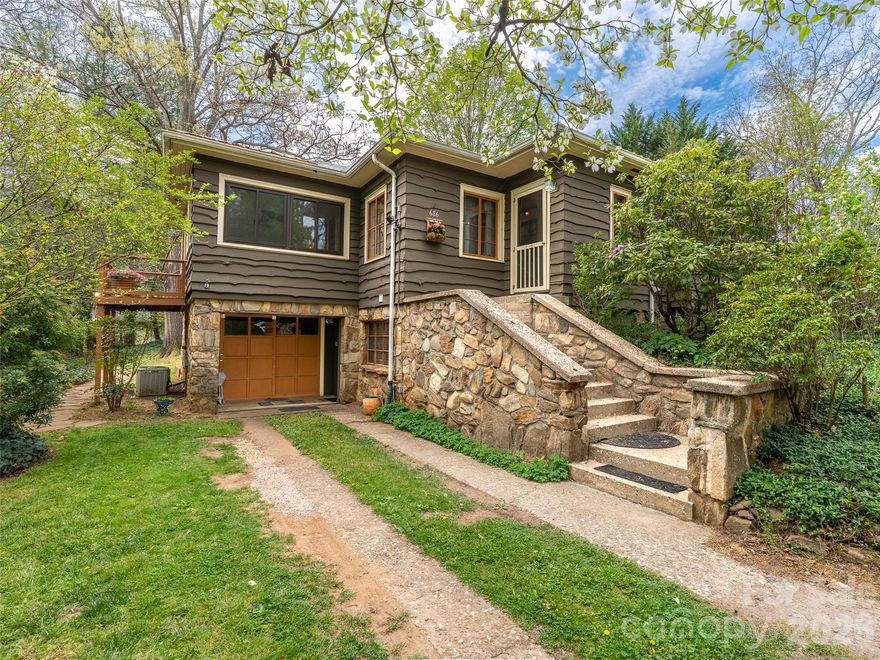 This enchanting East Asheville cottage, originally designed by renowned Architect Douglas Ellington for his mother, combines historical charm, income potential, and a prime location just minutes from downtown Asheville. Recently enhanced with a new metal roof and gas range, the home beautifully blends local history with modern upgrades. Situated on a private .84-acre double lot, the cedar-sided cottage features abundant perennial gardens. Its charming interior includes a cozy living room with a fireplace and a bright, sunny family room surrounded by trees and ample windows. A downstairs guest suite, complete with a private entrance, offers an extra bedroom and bath. Possibilities abound with an updated garage apartment (2018) & potential to subdivide.