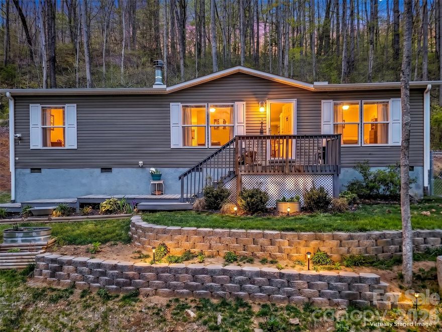 Welcome to 424 Arrington Acres Drive. This stunning 2021-built mountain residence sits on a generous 1.57-
acre parcel offering magnificent, sweeping mountain views. This home features a highly desirable split
floor plan, offering privacy for the spacious 3 bedrooms and 2 full bathrooms. The luxurious master
bathroom is a true retreat, boasting both a relaxing soaking tub and a separate stand-up shower. With an
open floor plan, entertaining is a breeze. Seating is available at the island, the dining room table, and
the living room. A wheelchair ramp provides thoughtful accessibility, leading directly from the driveway
to the back entrance. Using the back entrance, you will also find access to the fenced-in side yard.
Perfect for kids or animals to enjoy. For your peace of mind, the home has been pre-inspected, and the
acreage includes a dedicated storage shed. The home is conveniently located just 12 minutes from the
vibrant atmosphere of downtown Waynesville and approximately 20 minutes from Sylva, offering the perfect
balance of mountain privacy and town convenience. This is a fantastic opportunity to own an accessible, modern home with premium features in a highly desirable, picturesque setting.