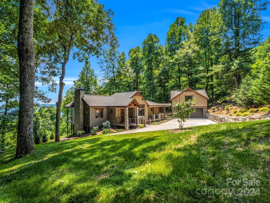 Nestled within the picturesque landscape of Brights Creek lies this charming home boasting long range mtn views and a view of Lake Adger. Step inside to discover a spacious open floor plan, where natural light dances freely, illuminating every corner of the inviting living space. The heart of the home is adorned with a open concept kitchen, perfect for culinary endeavors and entertaining guests. Detached garage featuring a suite above, providing ample space for guests or a private retreat. Membership available to Brights Creek Club offering a Fazio Championship golf course, bowling alley, pool, fitness, two dining options.