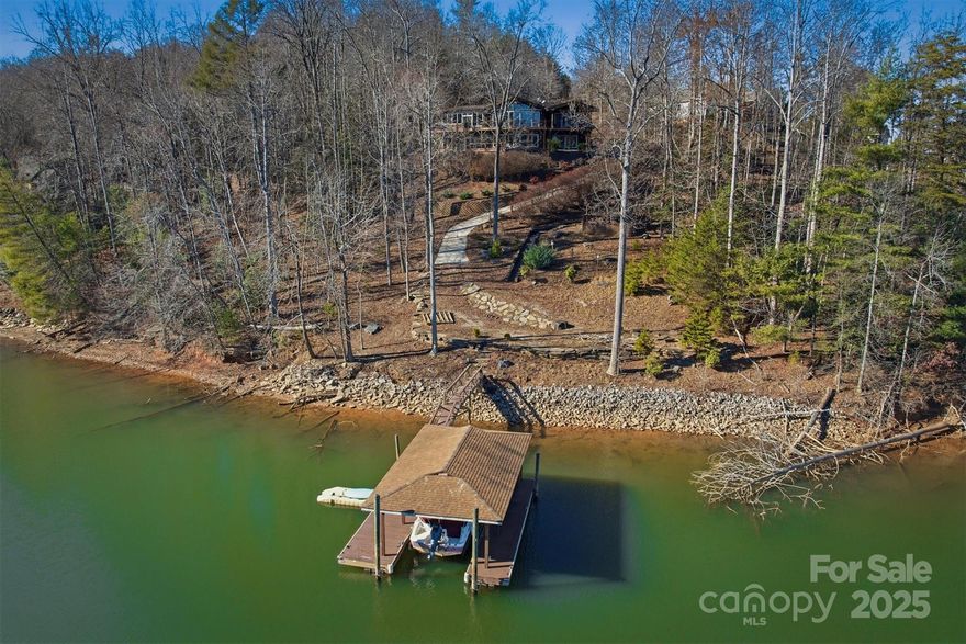 Perhaps the BEST DEAL on Lake James... this kind of waterfront home at this price is RARE! Located in the sprawling and beautiful gated Arbor community, with estimated travel of less than 2 hours from Charlotte and under 30 minutes to downtown Marion and Morganton. This home features custom craftsmanship showcasing vaulted tongue-and-groove ceilings and a nearly all-glass back wall, offering open-water views from nearly every room. On the main level, enjoy the spacious kitchen with granite countertops and stainless steel appliances. Also on the main level is a dreamy primary suite with a walk-in closet, back deck access, stunning VIEWS, vaulted ceiling, and an ensuite bath. The main floor also includes a laundry room with plenty of space to create a large pantry area, a half bath, private office, and formal dining room. Downstairs, spread out and entertain with ease in the family room and game room, along with two bedrooms plus a large flex room currently used as a 4TH BEDROOM. Buy with confidence... this home already has recent well water and pest inspections, an updated HVAC system, fresh full interior paint, electrical updates, dock and lift improvements, and septic repairs. As beautiful and well laid out as the interior is, the true STAR of the SHOW is the home’s upper and lower decks... INCREDIBLE VIEWS, an easy, short distance to the water, and a covered floating dock! Extras to note: Coming fully FURNISHED, attached carport, real hardwood floors, fire pit area, and a covered gazebo by the water. Enjoy low HOAs, NO water or septic bills, and NO city taxes. This home can be a SHORT-TERM RENTAL, meaning your DREAM HOME CAN MORE THAN PAY FOR ITSELF! (Not currently used as a rental)