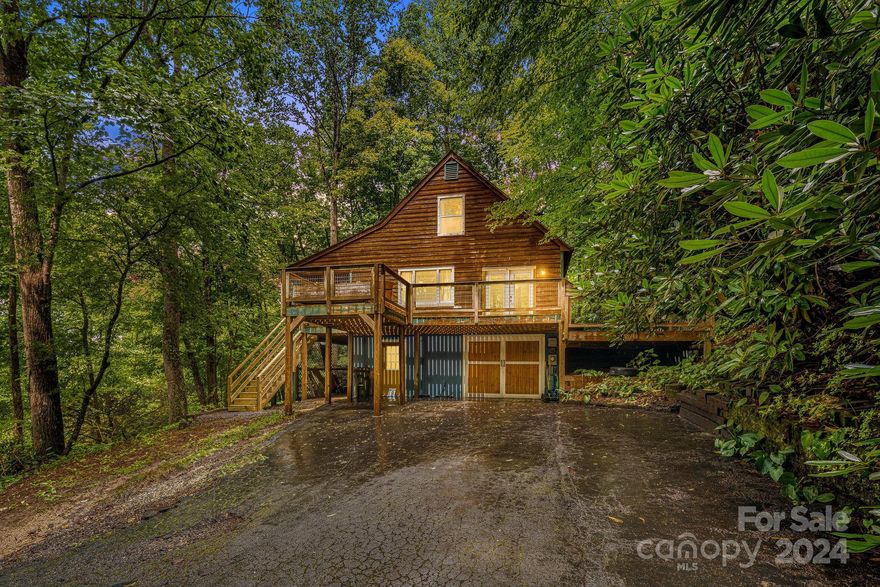 This great little home burrowed in the woods offers privacy without sacrificing convenience. Large windows and over 1,200 SF of decking perfectly integrates finished interior living space with the great outdoors, enhancing livability for a true mountain lifestyle with beautiful winter views. Exterior wood siding makes for a rustic cabin vibe, adding timeless character and charm. Wonderful kitchen layout with stainless steel appliances. The floor plan offers the perfect amount of division and warmth between rooms and plenty of storage throughout. Primary suite on the main level with a walk-in closet. Jack and Jill layout on the second story, utilizing space without compromising on functionality. Large recreation room located in the finished portion of the basement. Incredible location! This home is in close proximity to the Ecusta Trail & Coffee Shop. Convenient to downtown Hendersonville, I-26, Pisgah National Forest, and other outdoor attractions. shopping, and dining. Make it yours!
