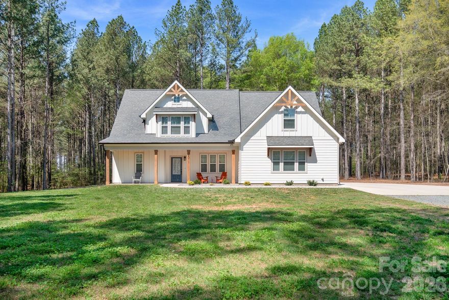 Almost New Modern Farmhouse on Nearly 2 Acres Surrounded by Beautiful Pines in Marshville!

Built in 2024, this beautifully crafted custom home offers the perfect blend of modern design and peaceful country living. Relax on the spacious covered front porch with cedar columns and watch the sunrise while enjoying your morning coffee overlooking the quiet natural surroundings. Inside, you'll find a spacious family room with a soaring 12-foot ceiling, an open layout perfect for entertaining, and custom Red Oak stair railings and steps that add warmth and character. The kitchen is the heart of the home, featuring a large 7-foot island with seating, tile backsplash, white shaker cabinets, stainless steel appliances, a breakfast area, and pantry. The refrigerator, washer, and dryer convey, making this home truly move-in ready. The Primary Suite is conveniently located on the main level, offering privacy and comfort. This inviting retreat includes tray ceilings, a cozy reading nook, and a spacious walk-in closet with a professional closet organization system. The Primary Bathroom features a frameless glass tiled shower, freestanding soaking tub, and a 72" double vanity. Upstairs you’ll find three additional bedrooms with one being oversized and a versatile bonus room, providing flexible space for guests, hobbies, or a home office. Since purchasing the home, the owners have added several thoughtful upgrades including custom blinds throughout the entire home (including doors), a whole-house water filtration system, and LeafFilter gutter protection. LVP flooring for the upstairs bedrooms is still in the box and will convey with the home should the new buyer wish to replace the current carpet. Tucked among beautiful mature pines on nearly 2 private acres, this home offers peaceful country living while remaining conveniently located to Monroe, Oakboro, and Locust. Located in the desirable New Salem/Piedmont School District, it provides the perfect blend of privacy, space, and accessibility.