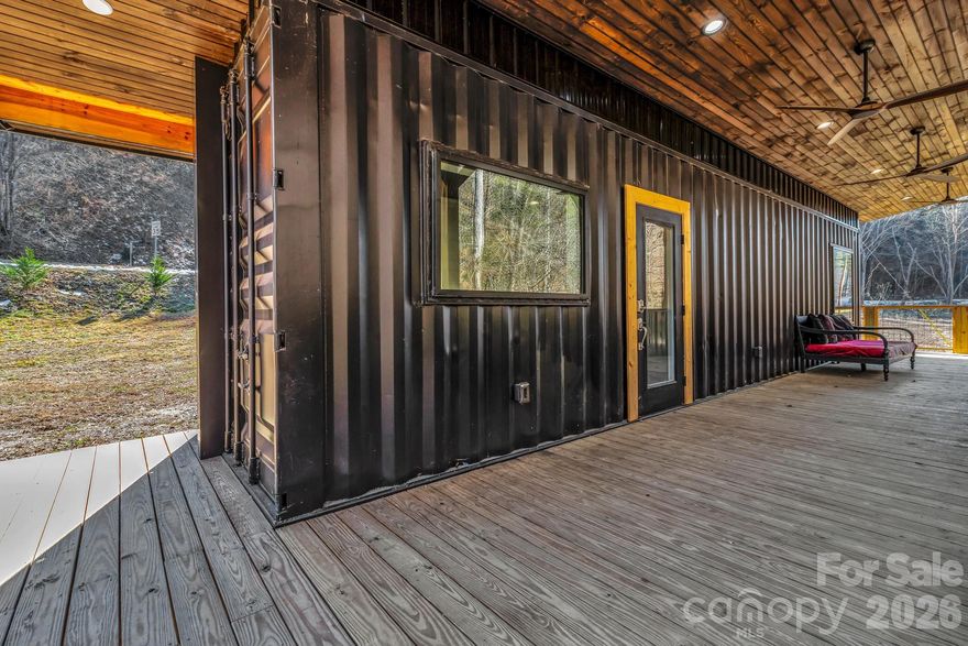 Welcome to this thoughtfully designed custom built container home offering modern efficiency and peaceful surroundings on .94 acres overlooking a beautiful creek. Fully built out and move-in ready, this unique property features a full kitchen, full bathroom, and private bedroom — maximizing every inch of space with smart design and quality finishes.

The kitchen is equipped with premium Big Chill appliances including an induction range, refrigerator, and freezer, blending style and performance in a compact footprint. Large windows invite natural light and bring the outdoors in, creating a bright and inviting atmosphere.

One of the standout features is the expansive 500 sq ft covered wrap around porch overlooking the creek — the perfect place to relax, entertain, or simply enjoy the soothing sound of flowing water year-round. This generous outdoor living space nearly doubles the functional footprint of the home and creates an incredible indoor-outdoor lifestyle.

Whether you’re looking for a turnkey short-term rental opportunity or a private mountain escape to unplug and enjoy the peace and quiet, this property offers incredible flexibility. Located just 10 minutes from downtown Hot Springs, you’ll have easy access to hiking trails, local shopping, great dining, and the area’s famous natural hot springs, all while being within an hour’s drive to larger cities like Asheville, NC and Knoxville, TN where you can enjoy even more dining, music and brewery options. 

Small footprint. Big experience. Rare opportunity.