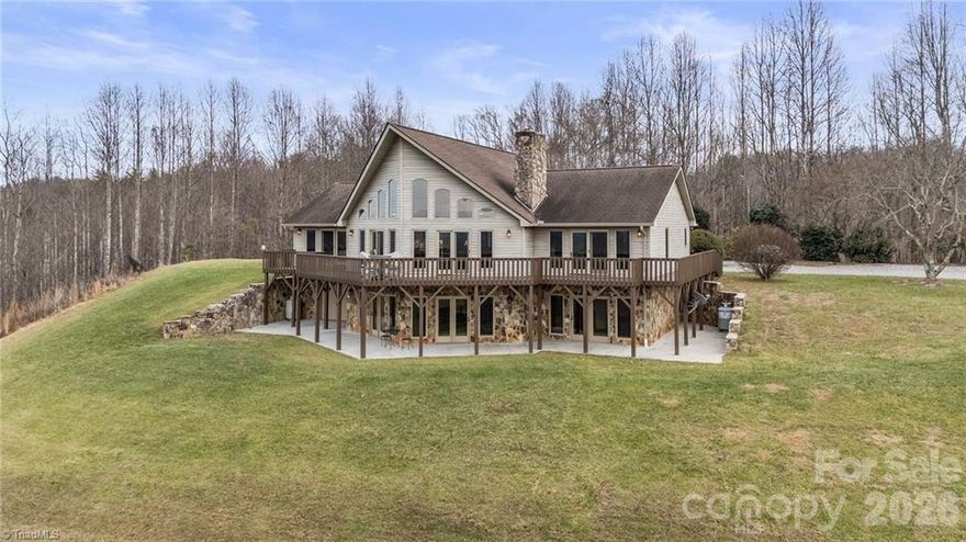 An unbelievably rare find near Kerr Scott Lake, this property offers breathtaking acreage and exceptional versatility. Set behind a gated entrance on 43 stunning acres, this 4BR/3.5BA home is designed to capture the beauty of its surroundings. The Great Room features a dramatic wall of windows with sweeping views, while the well-appointed kitchen is ideal for everyday living and entertaining. Two primary en-suites provide flexibility for guests or multi-generational living, with two additional bedrooms located on the walk-out basement level. All bedrooms enjoy scenic views. The expansive parcel includes two additional building sites, plus a bonus 2BR updated mobile home—perfect for guests, rental income, or extended family. Just minutes from Kerr Scott Lake, this is a truly special opportunity!