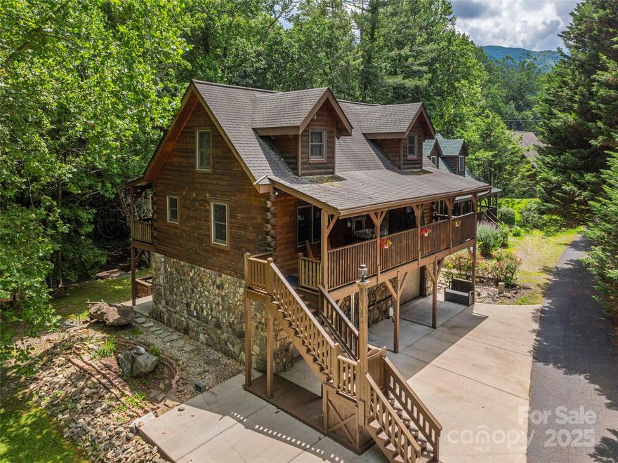 In the heart of Maggie Valley, this charming creekfront log home offers a blend of rustic character and modern comfort in a highly convenient location. Set on a level lawn overlooking the peaceful sights and sounds of the creek, the home features abundant outdoor living space with covered decks and porches ideal for relaxing and entertaining. Inside, a vaulted two-story great room creates a warm and inviting atmosphere with soaring ceilings and natural wood finishes. The main level provides easy living with a spacious primary bedroom and laundry room, while the upper level includes two additional bedrooms, a full bathroom, and an open loft perfect for a home office or extra lounge space. The lower level offers incredible flexibility with an oversized garage, bathroom, and the potential for 2nd living qtrs. The property is also being offered with the adjoining creekfront parcel(704k total). This property is a rare find in one of WNC’s most scenic and sought-after mountain communities.