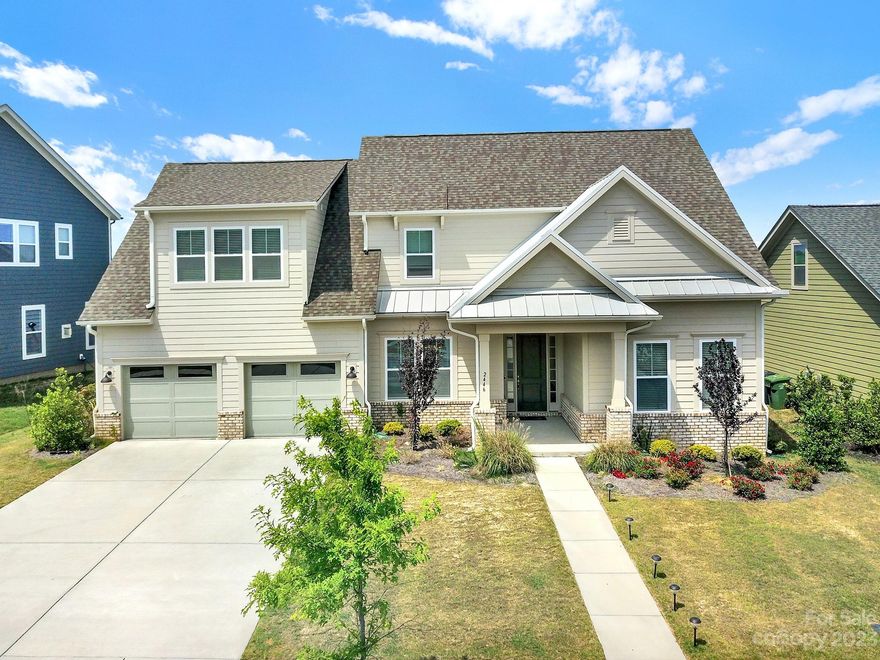 Stunning Paddlers Cove home offering the perfect blend of modern luxury and traditional charm. This Fielding Homes build is loaded with options, including hardwood floors throughout the first floor (except for the primary bedroom.) The primary bath features a tiled shower and a garden tub, providing the perfect space to relax and unwind. The kitchen is a chef's dream, featuring a large island, a farm sink, and spacious butlers pantry. Deluxe laundry room on the main floor and drop zone with built ins. Upstairs, you will find three spacious bedrooms and an open loft space. Enjoy the outdoors on the  covered patio with an outdoor stone fireplace, creating a perfect ambiance for outdoor living and entertaining. Highly desired location near Lake Wylie and Clover schools with LOW SC taxes! Neighborhood is amenity rich with Two Pools, open air pavilion, Field Day Park/Lake Wylie Sports Complex is right within the community  Don't miss the opportunity to make this home your own!