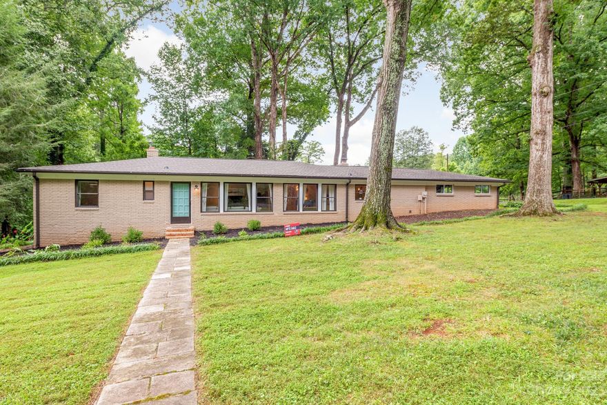 Welcome to 7022 Lakeside Drive in one of East Charlotte's gem neighborhoods, Grove Park.  This spacious Mid-Century ranch style home lives comfortably on more than a half acre corner lot in the heart of the neighborhood. A blend of smart updates and original charm strike a great balance for todays home buyers. The core of the home features the living room and dining room with original wood floors and arched openings plus the kitchen and informal dining area with a stunning Mid-Century brick fireplace. The south wing of the home features a secluded 350sqft bonus room perfect for any number of uses. The primary bedroom is on the north wing and features an updated private bathroom and sizable closet. Off the kitchen/dining area is an outdoor entertaining space with deck and wood screen wall for privacy. A few steps away you'll find the fire pit and shed. Grove Park is highly sought after with large lots, mature trees, Delta Creek Park, a number of lakes and a rare sense of community.