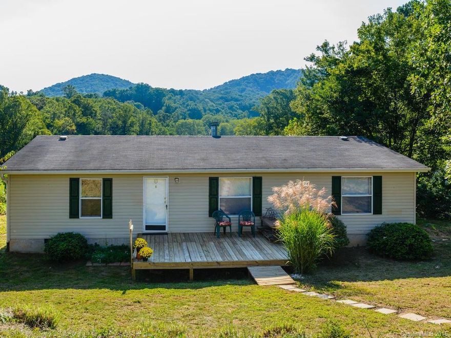 Meticulous home on double lot with big year round mountain views. Freshly painted and carpeted, this split plan home is move in ready. Spacious living room features fireplace.  Big walk in closet in master suite. Large deck overlooks big lot with space for a garden or animals. Home on permanent foundation in quiet rural area just 10 minutes from new Ingles at Sand Hill Road.