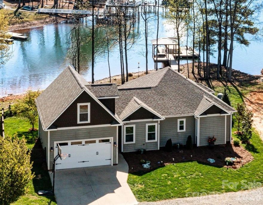 Welcome to Dockside at Songbird (former address 8024 Shipps Ln) — a turnkey Lake Norman waterfront escape featuring serene lake views, abundant windows, granite countertops, solid hardwood flooring, composite decking hot tub and an additional 400 sq ft finished bonus room above the garage.

Perfectly positioned for the lake lover, this beautifully maintained home offers effortless access to boating, paddleboarding, and kayaking directly from your private dock, with water depth suitable for year-round boating. Whether you're cruising to waterfront restaurants or enjoying a quiet morning on the lake, this is the lifestyle that draws buyers to Lake Norman.

The exterior showcases a combination of HardiPlank siding and cedar shake accents, offering low-maintenance durability with timeless architectural appeal. Inside, a thoughtfully designed 1,247 sq ft, 2-bedroom, 2-bath open-concept layout is enhanced by solid hardwood flooring and granite countertops. The additional 367 sq ft finished bonus space above the garage provides the perfect setting for a private home office, media lounge, or creative studio. Abundant windows fill the home with natural light while showcasing serene lake views.

Step outside and the experience continues. The private dock, complete with a charming gazebo and swing, creates the perfect setting for hosting friends, relaxing in the evenings, or simply taking in the peaceful lake views.

Recent updates and features include a new roof (2023), HVAC (Feb 2025), Hague WaterMax whole-house filtration system, approximately 120 feet of shoreline riprap (2022), composite decking, and a Hot Spring Highlife therapeutic saltwater spa with lift cover offering privacy (2024), adding to the home’s comfort and relaxation.

The low-maintenance fenced yard allows for easy living, while the 2-car garage and additional storage provide everyday functionality.

It’s not just a home — it’s a place to gather, relax, and make lasting memories on the lake.
