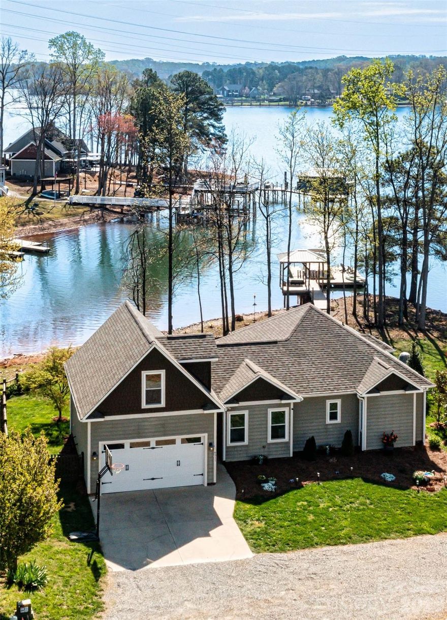 Welcome to Dockside at Songbird — a turnkey Lake Norman waterfront escape featuring serene lake views, abundant windows, granite countertops, solid hardwood flooring, hot tub and an additional 400 sq ft finished bonus room above the garage.

Perfectly positioned for the lake lover, this beautifully maintained home offers effortless access to boating, paddleboarding, and kayaking directly from your private dock, with water depth suitable for year-round boating. Whether you're cruising to waterfront restaurants or enjoying a quiet morning on the lake, this is the lifestyle that draws buyers to Lake Norman.

The exterior showcases a combination of HardiPlank siding and cedar shake accents, offering low-maintenance durability with timeless architectural appeal. Inside, a thoughtfully designed 1,247 sq ft, 2-bedroom, 2-bath open-concept layout is enhanced by solid hardwood flooring and granite countertops. The additional 367 sq ft finished bonus space above the garage provides the perfect setting for a private home office, media lounge, or creative studio. Abundant windows fill the home with natural light while showcasing serene lake views.

Step outside and the experience continues. The private dock, complete with a charming gazebo and swing, creates the perfect setting for hosting friends, relaxing in the evenings, or simply taking in the peaceful lake views.

Recent updates and features include a new roof (2023), HVAC (Feb 2025), Hague WaterMax whole-house filtration system, approximately 120 feet of shoreline riprap (2022), and a Hot Spring Highlife therapeutic saltwater spa with lift cover offering privacy (2024), adding to the home’s comfort and relaxation.

The low-maintenance fenced yard allows for easy living, while the 2-car garage and additional storage provide everyday functionality.

It’s not just a home — it’s a place to gather, relax, and make lasting memories on the lake.
