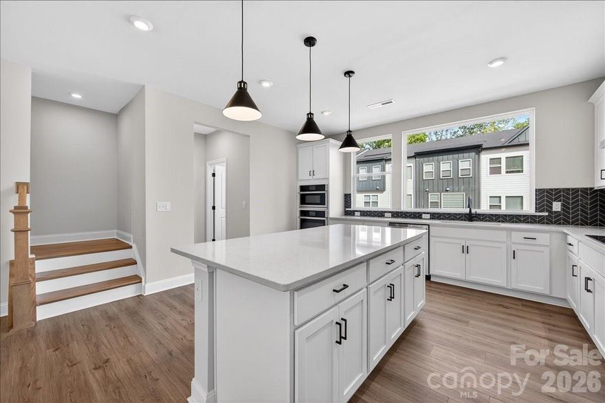 Just released in our sought-after model row, this beautifully designed townhome blends warmth, style, and functionality. From the moment you arrive, you’re welcomed with thoughtful elevated design throughout. The entry level features a versatile first-floor flex space with a full bath and tiled shower, perfect for a guest suite, home office, or additional living area. Step outside to a private back patio overlooking peaceful wooded views. At the heart of the home, the gourmet kitchen shines with crisp white cabinetry, quartz countertops, and a striking wraparound chevron mosaic in dramatic gray marble porcelain tile. Natural light pours in, enhancing the elevated yet inviting feel. The kitchen flows seamlessly into the open-concept great room and out to a second-level outdoor living area. White railing details and rich brown flooring add a modern, high-contrast finish throughout. Upstairs, retreat to the expansive primary suite featuring a tray ceiling and a spa-like bath with warm cabinetry and floor-to-ceiling marble tile, offering timeless beauty with low-maintenance durability. With designer finishes, flexible living spaces, and an elevated aesthetic throughout, this home won’t last long.